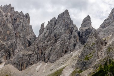 Dolomiti Alpleri güzel dağ manzarası. Dolomitlerde Rocky kulesi zirveleri. Yeşil dağ vadisindeki yürüyüş yolunda yaz manzarası ve bulutlu mavi gökyüzü.