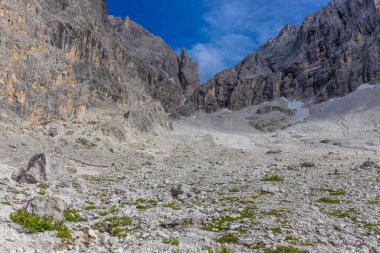 Dolomiti Alpleri güzel dağ manzarası. Dolomitlerde Rocky kulesi zirveleri. Yeşil dağ vadisindeki yürüyüş yolunda yaz manzarası ve bulutlu mavi gökyüzü.
