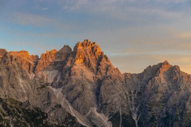 Dolomiti Alpleri güzel dağ manzarası. Dolomitlerde Rocky kulesi zirveleri. Yeşil dağ vadisindeki yürüyüş yolunda yaz manzarası ve bulutlu mavi gökyüzü.