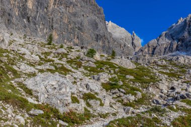 Dolomiti Alpleri güzel dağ manzarası. Dolomitlerde Rocky kulesi zirveleri. Yeşil dağ vadisindeki yürüyüş yolunda yaz manzarası ve bulutlu mavi gökyüzü.
