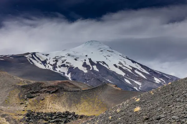 stock image Osorno volcano mountain summit in Chile, Patagonia Andes. The ring of fire volcanic landscape with crater and lava active volcano in South America. Red rock frozen lava and snow on volcano top