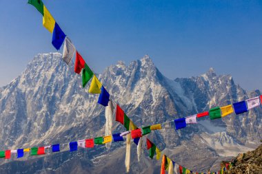 Colorful Nepali and Tibetan prayer flags fluttering in the majestic mountains of Nepal. Symbolizing peace, compassion, and blessings, flags adorn the serene landscape of Himalaya mountains clipart