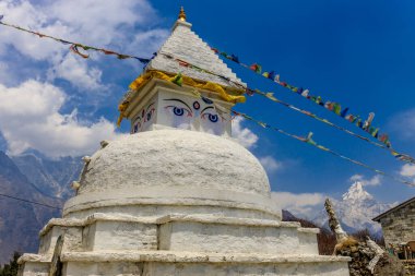 Stupa 'nın Nepal' de Buda gözleri var. Himalaya dağları ve Katmandu başkentinde Budizm Pagoda 'nın dini binası. Budizm 'in kutsal mekanı. Güzel, huzurlu bir yerde bayrakları var.