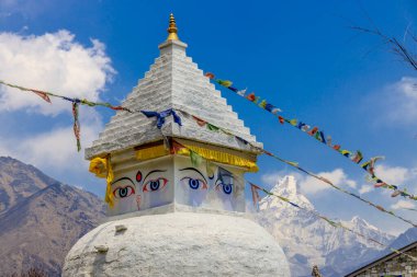 Stupa 'nın Nepal' de Buda gözleri var. Himalaya dağları ve Katmandu başkentinde Budizm Pagoda 'nın dini binası. Budizm 'in kutsal mekanı. Güzel, huzurlu bir yerde bayrakları var.