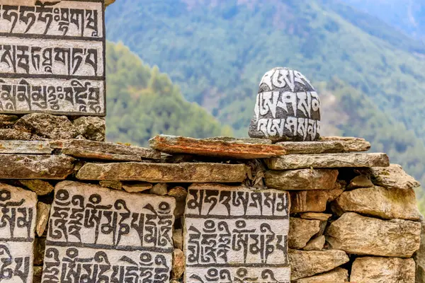 Nepal kutsal taşları. Manikür. Yüzeyine mantra yazılıp oyulmuş. Everest Ana Kampı 'ndaki dağ yürüyüşü yolunda taşlı bölge. Nepalli Budist mantra Om Mani Padme Hum on rock