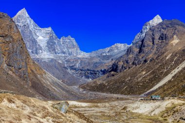 Himalaya dağları yüksek rakımlı kar ve buzul zirveleriyle kaplı. Nepal 'deki Everest Merkez Kampı Solo Khumbu yürüyüş bölgesi. Güzel Himalayalar. Mavi gökyüzünün altında sekiz bin dolarlık bir zirve.