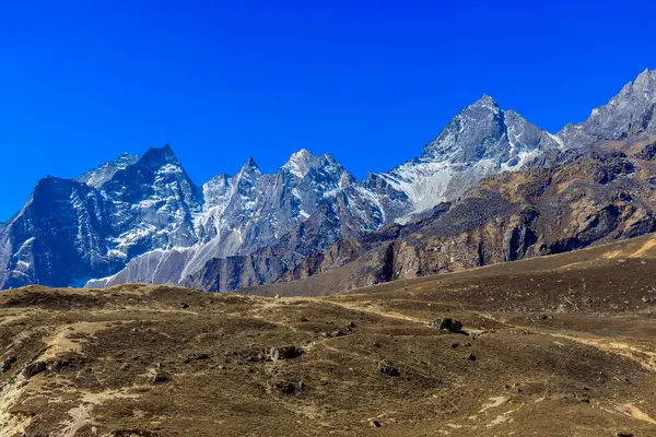 Himalaya dağları yüksek rakımlı kar ve buzul zirveleriyle kaplı. Nepal 'deki Everest Merkez Kampı Solo Khumbu yürüyüş bölgesi. Güzel Himalayalar. Mavi gökyüzünün altında sekiz bin dolarlık bir zirve.