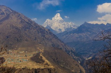 Ama Dablam dağı zirvesi Himalaya dağ sırası, Nepal 'de. Everest Ana Kampı 'nın yürüyüş bölgesinde baharda bulutlarla kaplı güzel yüksek irtifa dağ manzarası. Himalaya 'da yürüyüş
