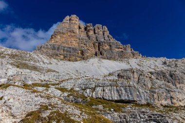 Dolomitler yaz aylarında mavi gökyüzünün altında güzel bir kaya kulesi oluştururlar. İtalyan Alp Dağları yüksek rakımlı kayalık duvarların manzaralı manzarası uçurumun görkemli manzarası ve yeşil vadi