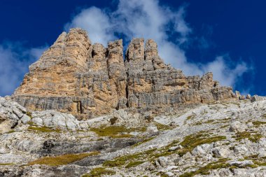 Dolomitler yaz aylarında mavi gökyüzünün altında güzel bir kaya kulesi oluştururlar. İtalyan Alp Dağları yüksek rakımlı kayalık duvarların manzaralı manzarası uçurumun görkemli manzarası ve yeşil vadi