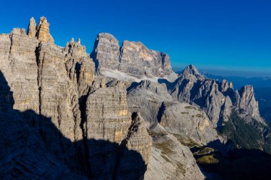 Dolomitler yaz aylarında mavi gökyüzünün altında güzel bir kaya kulesi oluştururlar. İtalyan Alp Dağları yüksek rakımlı kayalık duvarların manzaralı manzarası uçurumun görkemli manzarası ve yeşil vadi