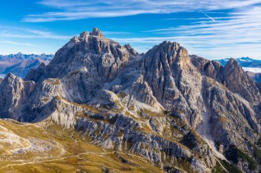 Dolomitler yaz aylarında mavi gökyüzünün altında güzel bir kaya kulesi oluştururlar. İtalyan Alp Dağları yüksek rakımlı kayalık duvarların manzaralı manzarası uçurumun görkemli manzarası ve yeşil vadi