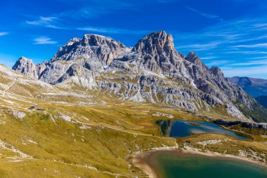 Dolomitler yaz aylarında mavi gökyüzünün altında güzel bir kaya kulesi oluştururlar. İtalyan Alp Dağları yüksek rakımlı kayalık duvarların manzaralı manzarası uçurumun görkemli manzarası ve yeşil vadi