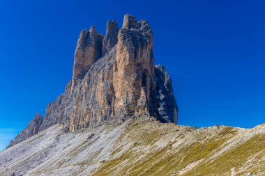 Dolomitler yaz aylarında mavi gökyüzünün altında güzel bir kaya kulesi oluştururlar. İtalyan Alp Dağları yüksek rakımlı kayalık duvarların manzaralı manzarası uçurumun görkemli manzarası ve yeşil vadi