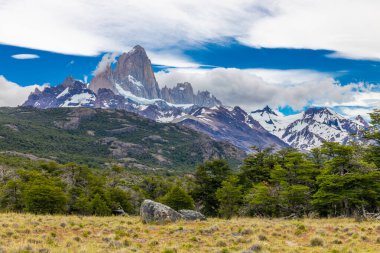 El Chalten, Arjantin 'deki Patagonya dağları. Monte Fitzroy ve Cerro Torre göl kıyısındaki granit duvarlara tırmanıyor. Buz dağları yüzen buzdağları ve kara bulutlarla. Patagonya havası ve dağ sıraları.