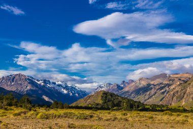 El Chalten, Arjantin 'deki Patagonya dağları. Monte Fitzroy ve Cerro Torre göl kıyısındaki granit duvarlara tırmanıyor. Buz dağları yüzen buzdağları ve kara bulutlarla. Patagonya havası ve dağ sıraları.