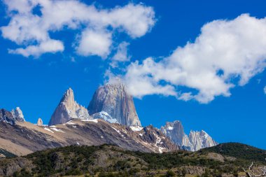 El Chalten, Arjantin 'deki Patagonya dağları. Monte Fitzroy ve Cerro Torre göl kıyısındaki granit duvarlara tırmanıyor. Buz dağları yüzen buzdağları ve kara bulutlarla. Patagonya havası ve dağ sıraları.