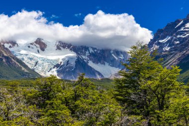 El Chalten, Arjantin 'deki Patagonya dağları. Monte Fitzroy ve Cerro Torre göl kıyısındaki granit duvarlara tırmanıyor. Buz dağları yüzen buzdağları ve kara bulutlarla. Patagonya havası ve dağ sıraları.