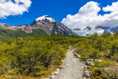El Chalten, Arjantin 'deki Patagonya dağları. Monte Fitzroy ve Cerro Torre göl kıyısındaki granit duvarlara tırmanıyor. Buz dağları yüzen buzdağları ve kara bulutlarla. Patagonya havası ve dağ sıraları.