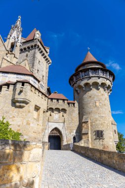 Mavi gökyüzünün altındaki kale simgesi. Avusturya 'da ortaçağ kalesi. Viyana çevresindeki antik tarihi yerler. Burg Kreuzenstein Kalesi. Dışarıdan kuleleri olan eski antik bir kale.