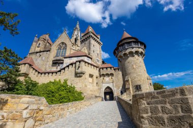 Mavi gökyüzünün altındaki kale simgesi. Avusturya 'da ortaçağ kalesi. Viyana çevresindeki antik tarihi yerler. Burg Kreuzenstein Kalesi. Dışarıdan kuleleri olan eski antik bir kale.