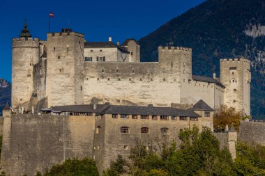 Avusturya 'nın Salzburg şehrinde. Kiliseler, şato, köprü ve arkasında dağlar olan güzel şehir manzarası. Salzburg 'un ünlü şehirleri ve turistik yerleri.