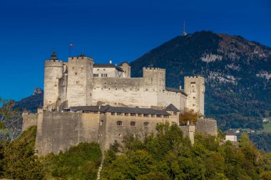Avusturya 'nın Salzburg şehrinde. Kiliseler, şato, köprü ve arkasında dağlar olan güzel şehir manzarası. Salzburg 'un ünlü şehirleri ve turistik yerleri.