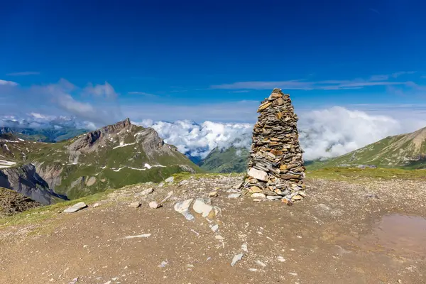 Zirvedeki taş piramit ve patikayı işaret eden geçit.