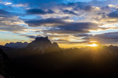 Dolomitlerde gün batımı dağ siluetleri ve arka planda yanan kırmızı gökyüzü olan güzel bir manzara. Doloiti Alplerinde gün doğumu ve gün batımı