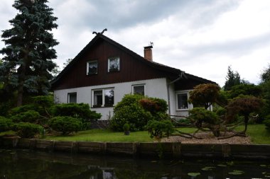 Bu büyüleyici görüntü, Almanya 'nın pitoresk bir bölgesi olan Lubbenau / Spreewald' ın dingin güzelliğini yansıtıyor. Fotoğrafta yemyeşil sularda salınan sakin bir kanal var. Geleneksel tekneler suyun üzerinde nazikçe yüzüyor. Yoğun orman