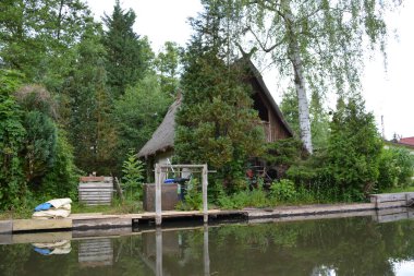Bu büyüleyici görüntü, Almanya 'nın pitoresk bir bölgesi olan Lubbenau / Spreewald' ın dingin güzelliğini yansıtıyor. Fotoğrafta yemyeşil sularda salınan sakin bir kanal var. Geleneksel tekneler suyun üzerinde nazikçe yüzüyor. Yoğun orman