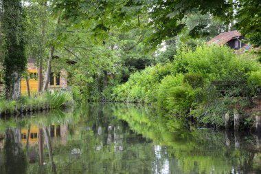 Bu büyüleyici görüntü, Almanya 'nın pitoresk bir bölgesi olan Lubbenau / Spreewald' ın dingin güzelliğini yansıtıyor. Fotoğrafta yemyeşil sularda salınan sakin bir kanal var. Geleneksel tekneler suyun üzerinde nazikçe yüzüyor. Yoğun orman