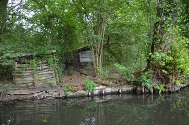 Bu büyüleyici görüntü, Almanya 'nın pitoresk bir bölgesi olan Lubbenau / Spreewald' ın dingin güzelliğini yansıtıyor. Fotoğrafta yemyeşil sularda salınan sakin bir kanal var. Geleneksel tekneler suyun üzerinde nazikçe yüzüyor. Yoğun orman