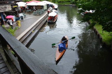 Bu büyüleyici görüntü, Almanya 'nın pitoresk bir bölgesi olan Lubbenau / Spreewald' ın dingin güzelliğini yansıtıyor. Fotoğrafta yemyeşil sularda salınan sakin bir kanal var. Geleneksel tekneler suyun üzerinde nazikçe yüzüyor. Yoğun orman