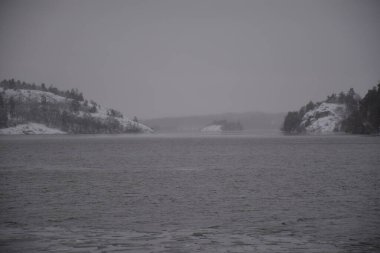 Bulutlu bir günde, kışın gölü olan güzel bir nehir manzarası.