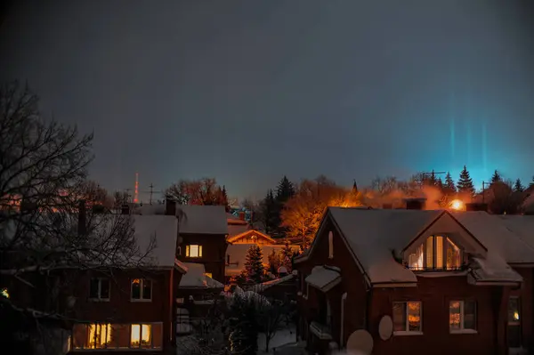 Güzel gece gökyüzünün altında karla kaplanmış, sakin ve sakin bir atmosfer yaratan resimsel bir ev dizisi.