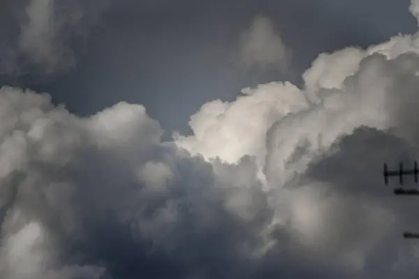 Çarpıcı bir fotoğraf, atmosferik derinlik ve dokularla dolu dramatik ve bulutlu bir gökyüzü gösteriyor.