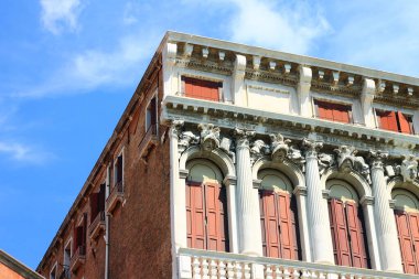 Bu çarpıcı tuğla bina Venedik İtalya 'daki açık mavi gökyüzüne karşı klasik bir tasarım sergiliyor.
