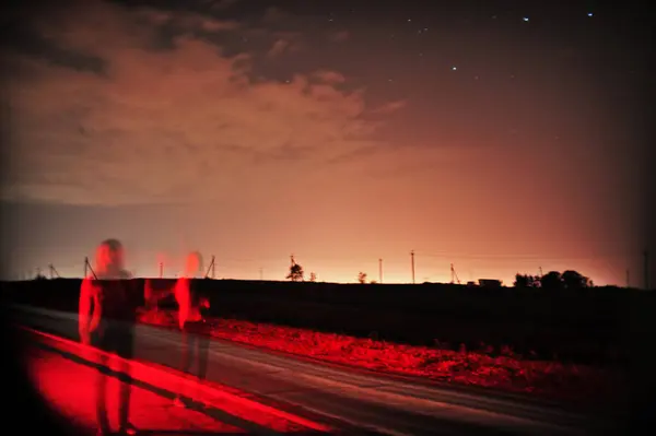 Parlak yıldızlı huzurlu bir gece manzarası, alacakaranlık bulutları, ve sakin bir gökyüzüne karşı siluetli elektrik hatları