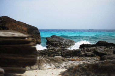 Çok güzel turkuaz dalgaların sert kayalara, Tayland 'a çarptığını gösteren nefes kesici bir kıyı sahnesi.