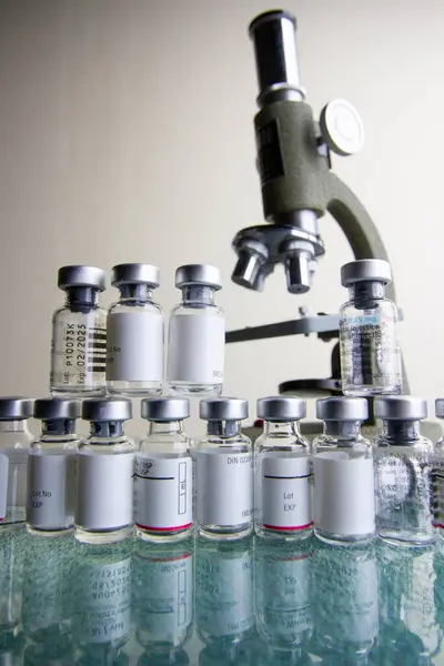 Antika mikroskop, küçük bir laboratuarda küçük ilaç şişelerinden oluşan bir koleksiyon..