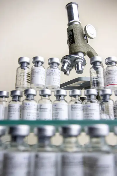 Antika mikroskop, küçük bir laboratuarda küçük ilaç şişelerinden oluşan bir koleksiyon..