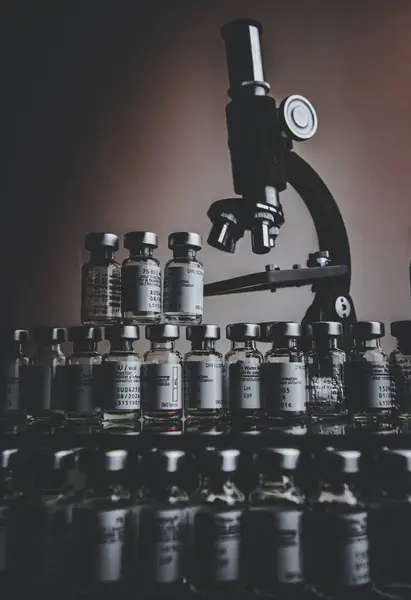 Antika mikroskop, küçük bir laboratuarda küçük ilaç şişelerinden oluşan bir koleksiyon..