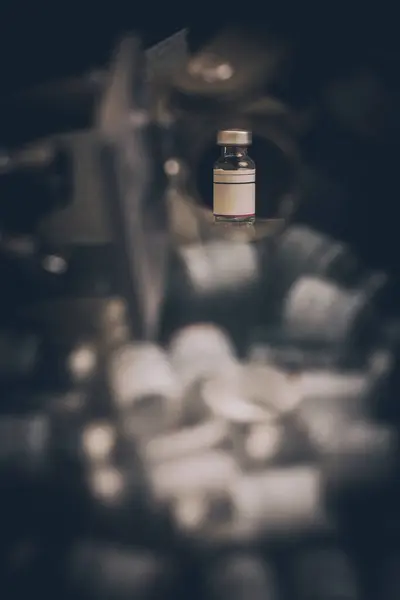 İğrenç bir gülümseme, küçük bir bilim laboratuarındaki eski bir mikroskobun camına yansıyor..