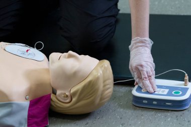 İlk solunum çalışanı suni teneffüs ve düzgün defibrilatör prosedürü uygular..