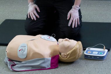 İlk solunum çalışanı suni teneffüs ve düzgün defibrilatör prosedürü uygular..