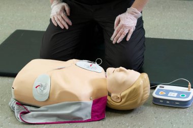 İlk solunum çalışanı suni teneffüs ve düzgün defibrilatör prosedürü uygular..