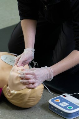 İlk solunum çalışanı suni teneffüs ve düzgün defibrilatör prosedürü uygular..