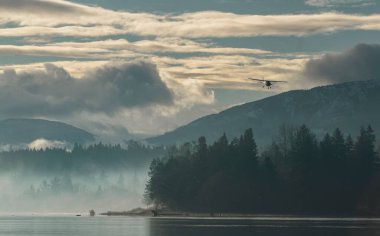 Scenic Light Aircraft Landing Over Misty Forest and Mountain Landscape. Cessna 172 single engine aircraft clipart