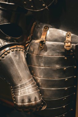 Ortaçağ zırh eldiveni ve belinde metal perçinler ve deri kayışlar var..